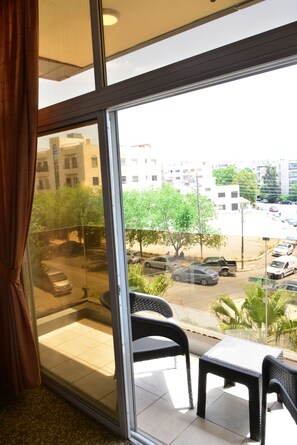 A balcony with a view of a street and buildings.