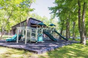 A playground with slides and a playhouse.