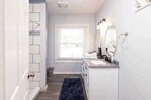 Bathtub, hair dryer, towels, shampoo