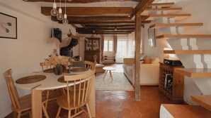 A cozy living space with a dining area, a staircase, and a sofa.