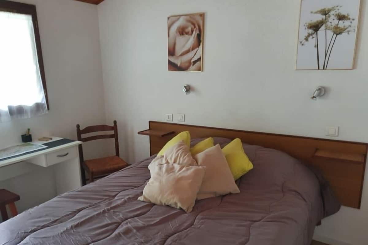 Ein Schlafzimmer mit einem Bett, einem Schreibtisch und einem Stuhl.