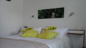 A bedroom with a bed, white bedding, and two yellow pillows. - Le Hameau de la Courbière (Tarascon-sur-Ariege)