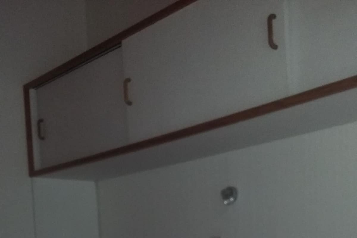 Ein Hotelzimmer mit Bett, Kissen, Kopfteil und Kleiderschrank.