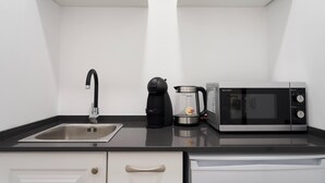 A kitchen with a stainless steel sink, a coffee maker, and a microwave. - Downtown Loulé  (Loulé)