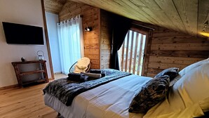 Une chambre confortable dans un chalet en bois, avec un lit, une petite table et une chaise.