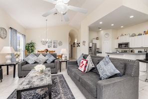 Relax in this stylish living room with a sofa, coffee table, and dining area.