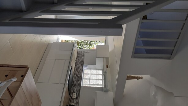 A modern interior with a staircase, a window with a view, and a white wall. - Apartment 100 m from the beach (Les Sables-d'Olonne)