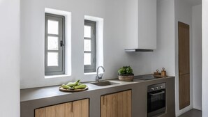 A modern kitchen with a built-in oven, a sink, and a window above the counter. - Indigo 4 Bedroom Villa Sea View Private Pool (Paros)