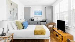 A modern hotel room with a bed, a television, a desk with a coffee maker, and a large window with blinds. - B1 at Saint Philip Square, One Block to King, Spacious Gem (Charleston)