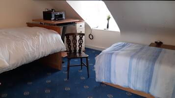 Un dormitorio con dos camas, un escritorio con una impresora, una silla y una ventana con vistas.