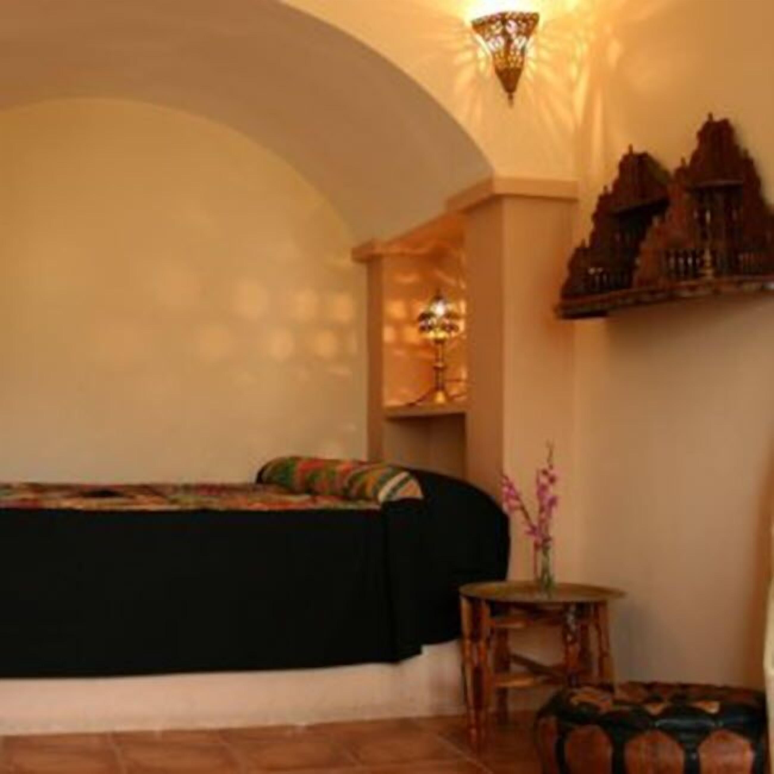 Une pièce confortable avec un lit, une petite table et un élément décoratif mural.