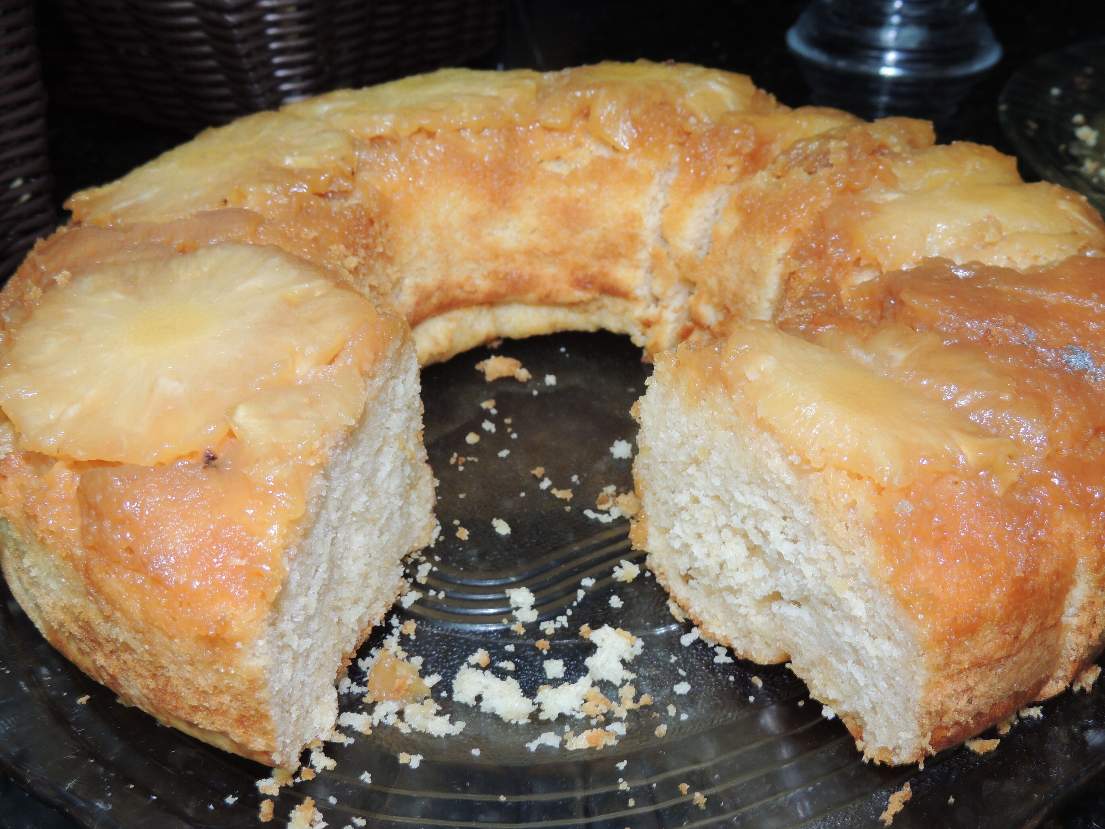 Un pastel invertido de piña sobre un plato de vidrio.