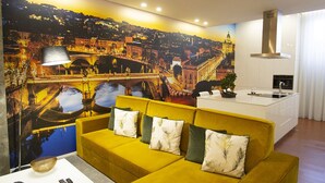 Una sala de estar moderna con un sofá amarillo, una isla blanca con pileta y un mural con vista a la ciudad.