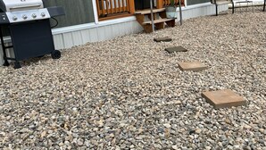A house with a porch, a grill, and a gravel driveway. - New Tiny home on cattle ranch 80 acres gorgeous view Close to forest McPhee Mesa (Dolores)