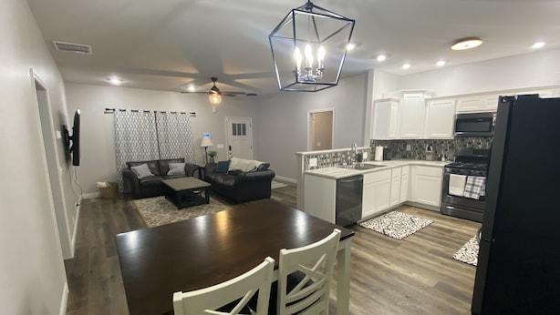 A modern kitchen with a central island, white cabinetry, and a black refrigerator. - Great new home - just for you! (Newburgh)