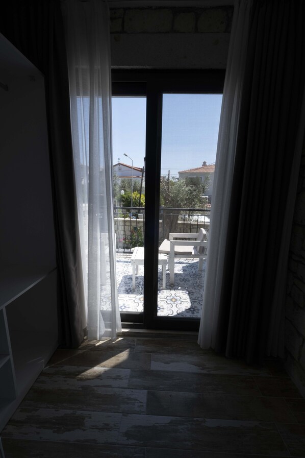 A room with a view of a balcony, a sliding glass door, and a patterned floor. - Mi Otel Alacati (Cesme)