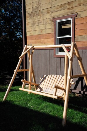 Un portique en bois se trouve devant une maison qui a une fenêtre.
