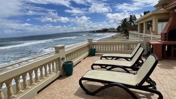 A balcony with two lounge chairs and a view of the ocean. - Oceanfront 3 Bdrm House on Surf Beach near Rincon with Private Beach Access (Aguada)