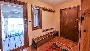 A room with a wooden bench, a door, a window, and a light fixture. - Ski-In/Ski-Out, Hot Tub, Fireplace & Mountain Views (Crested Butte)
