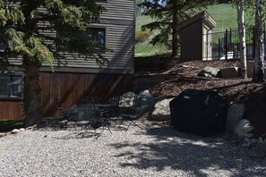 A gravel driveway with a metal grill, a black bag, and a small shed. - Ski-In/Ski-Out, Hot Tub, Fireplace & Mountain Views (Crested Butte)