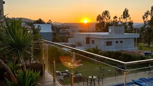 Terrassa al terrat amb piscina, zona de seients i plantes en testos.