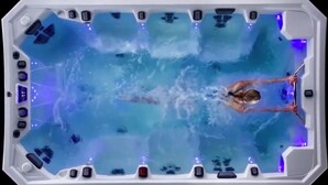 Un jacuzzi con una persona usando un chorro de agua.