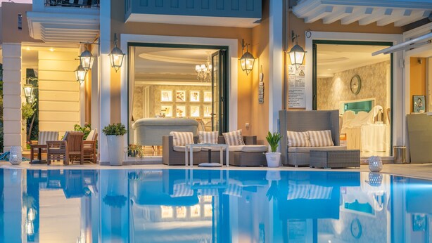 A poolside area with seating arrangements and a clear pool. - Hotel Orion (Lefkada)