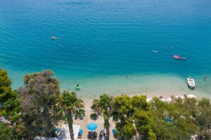 Di pantai, kursi berjemur, payung pantai, dan handuk pantai