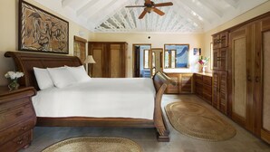Un dormitorio espacioso con una cama grande, muebles de madera y un ventilador de techo.