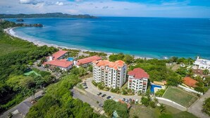Um resort à beira-mar com vários edifícios, uma praia e vista clara do oceano.