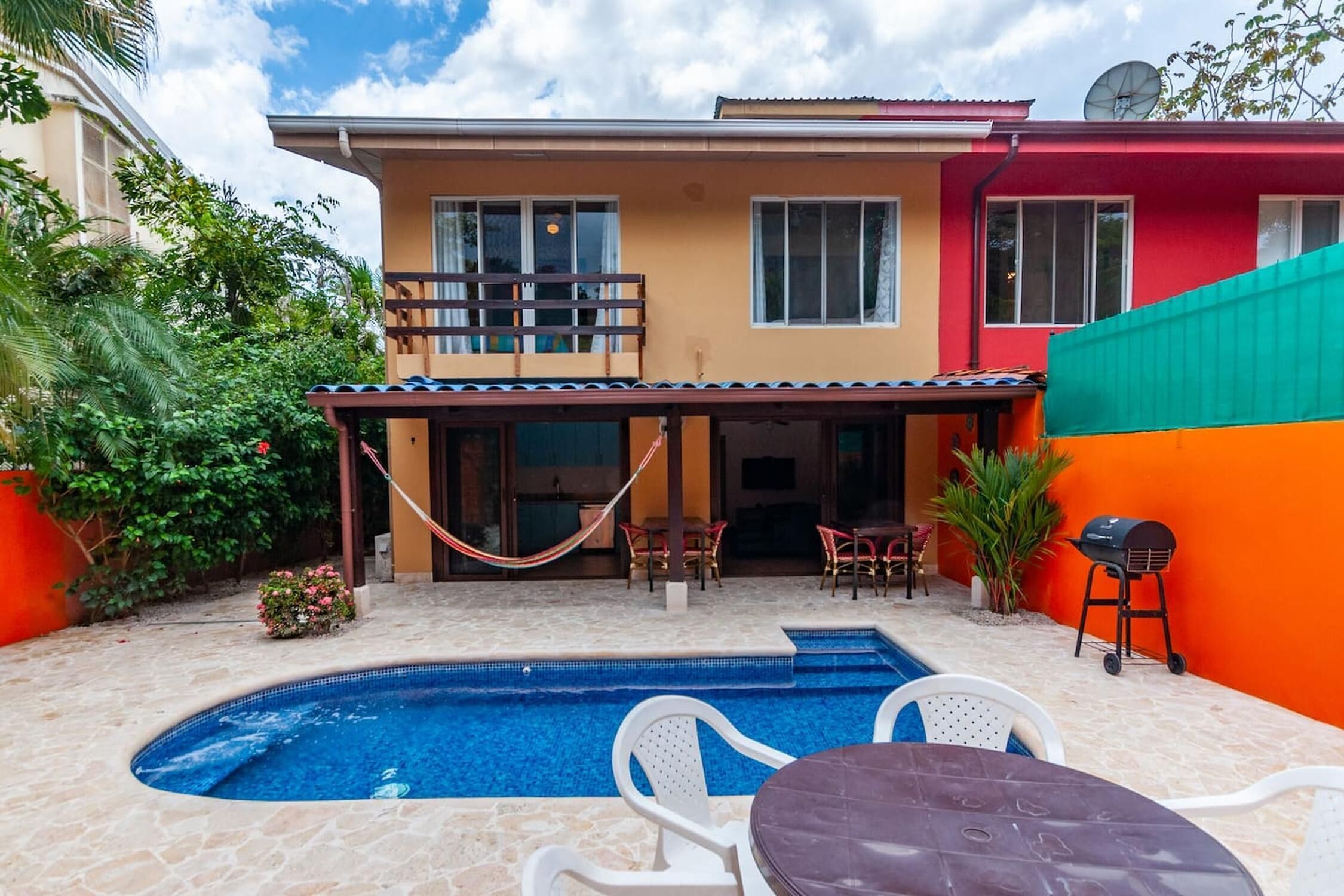 A house with a swimming pool, outdoor furniture, and a barbecue grill.