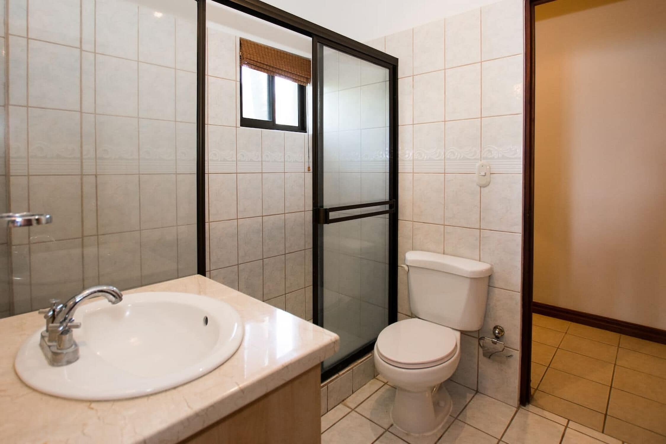 Une salle de bain équipée d’un lavabo, de toilettes et d’une douche à parois en verre.