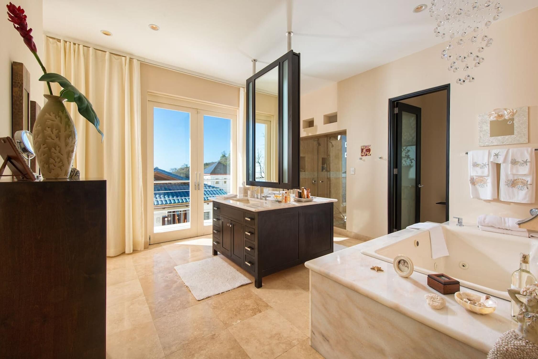 A modern bathroom with a large mirror, a bathtub, and a vanity with a sink.
