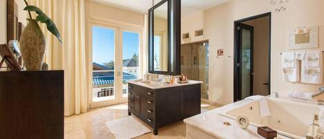 A modern bathroom with a large mirror, a bathtub, and a vanity with a sink.