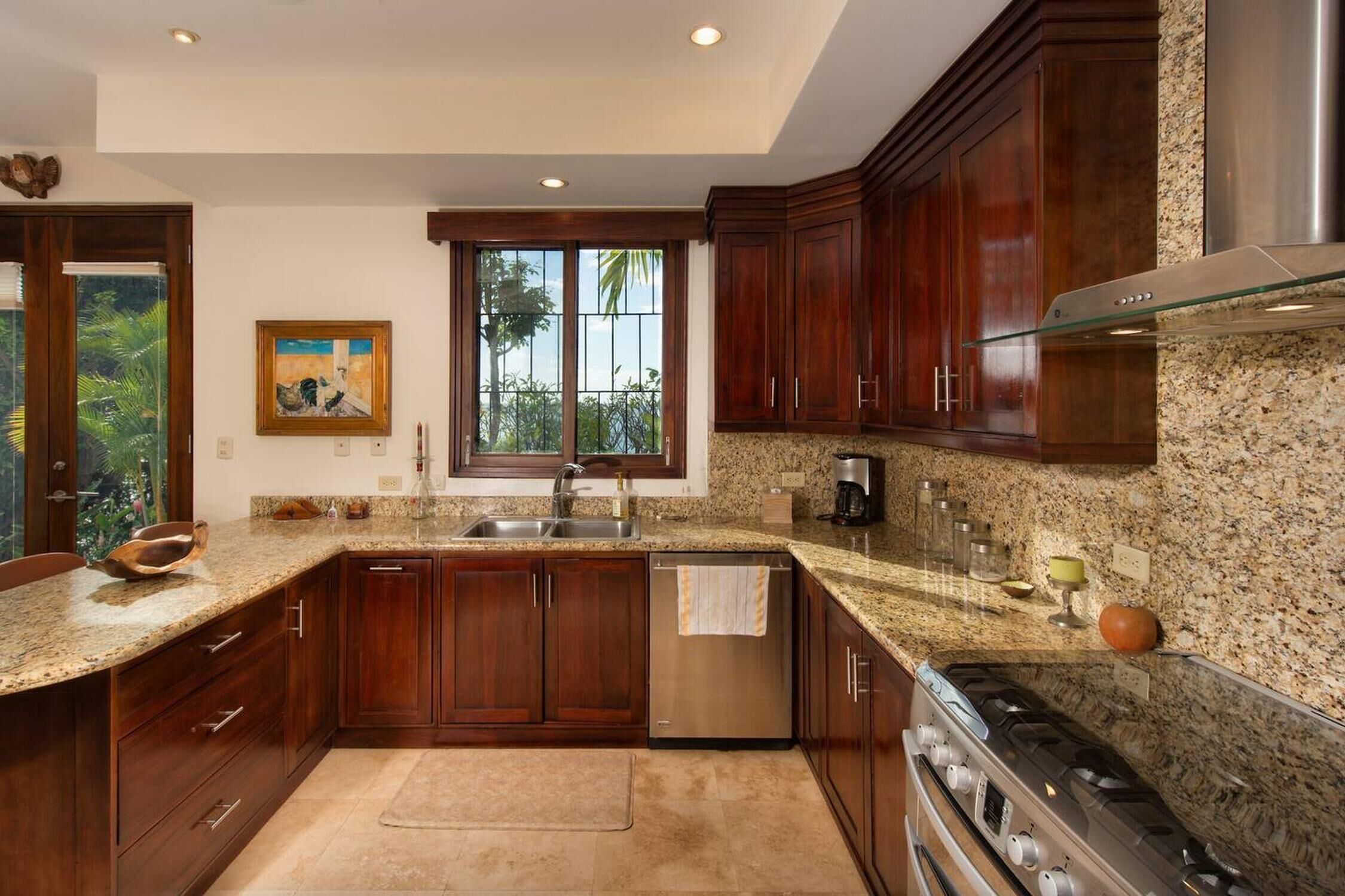 A modern kitchen with granite countertops, stainless steel appliances, and wooden cabinets.