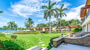 A resort with a pool, palm trees, and a well-maintained lawn. - Stylish Split-Level Condo with a Shaded Terrace, Direct Beach Access, and Resort-Style Community Amenities (Cabo Velas)