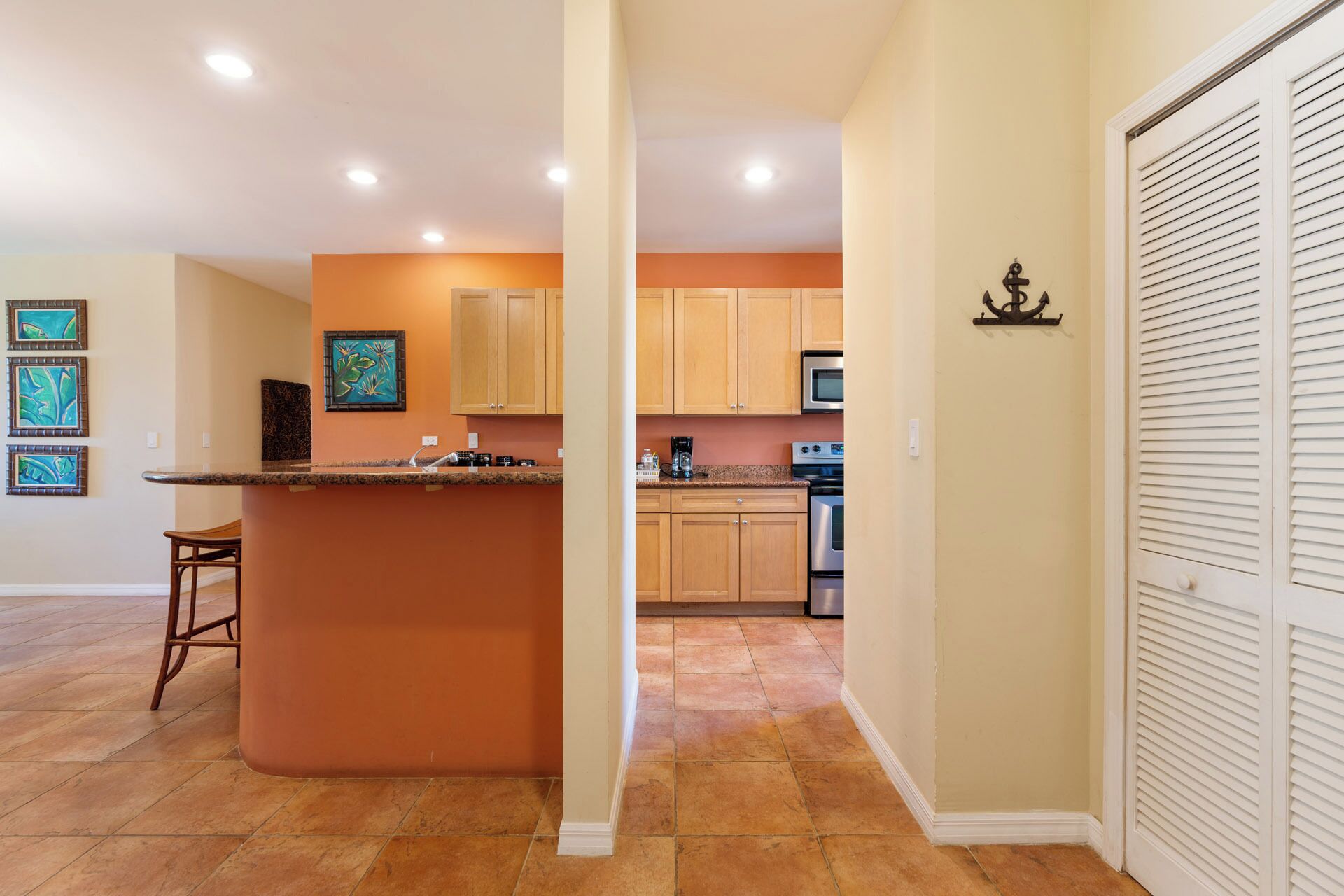 A kitchen with wooden cabinets, a central island, and a microwave.