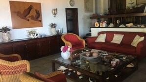 A living room with wicker furniture, a glass coffee table, and a red sofa. - Villa with swimming pool and views of the Argentario. WiFi free (Ansedonia)
