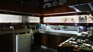 A kitchen with wooden cabinets, a gas stove, and a window providing natural light. - Villa with swimming pool and views of the Argentario. WiFi free (Ansedonia)