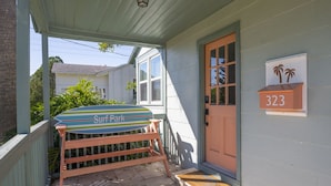 A porch with a surfboard and a mailbox with the number 323. - Surf Park House – Historic Jax Beach Home, 3 Blocks to Beach, Pet Friendly (Jacksonville Beach)