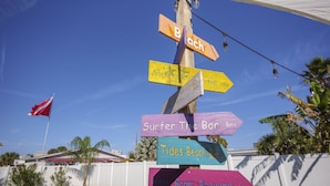A wooden signpost with multiple directional signs pointing to various local attractions. - Surf Park House – Historic Jax Beach Home, 3 Blocks to Beach, Pet Friendly (Jacksonville Beach)
