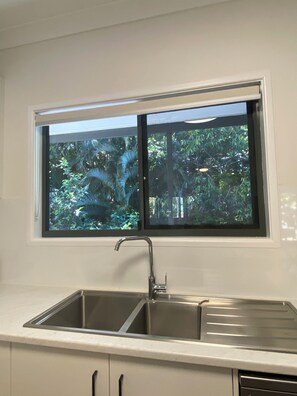 A kitchen with a window above a double sink. - Merindah - Pet-Friendly, Coastal Living at its Best (Agnes Water)