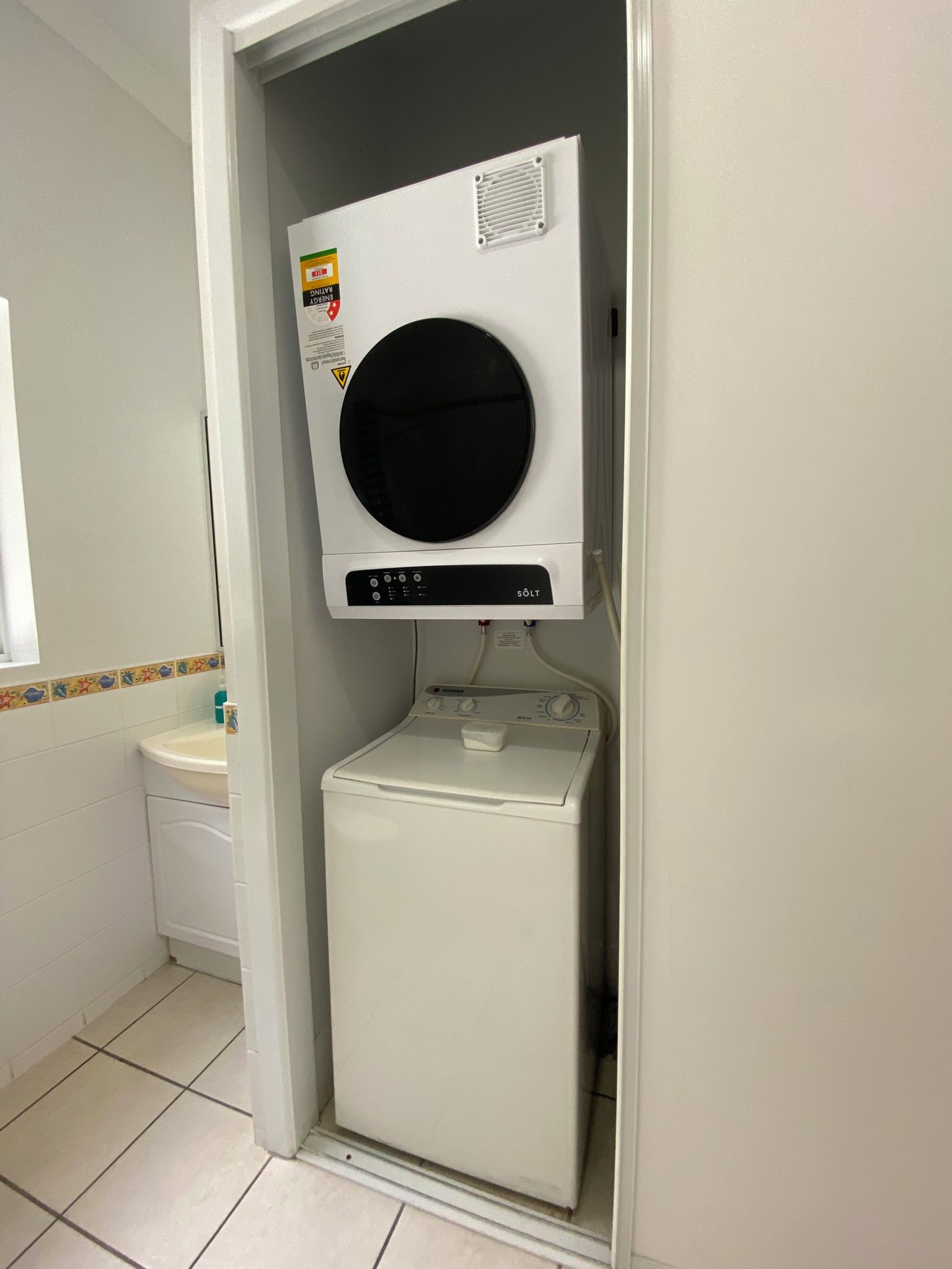 A compact laundry room with a front-loading washing machine and a dryer.