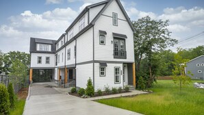 Een tweelaags huis met garage, een overdekte oprit en een verzorgd gazon.
