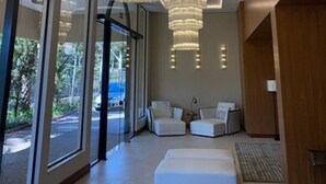 A modern interior with large windows, a chandelier, and seating area. - Class Hotel Piracicaba (Piracicaba)