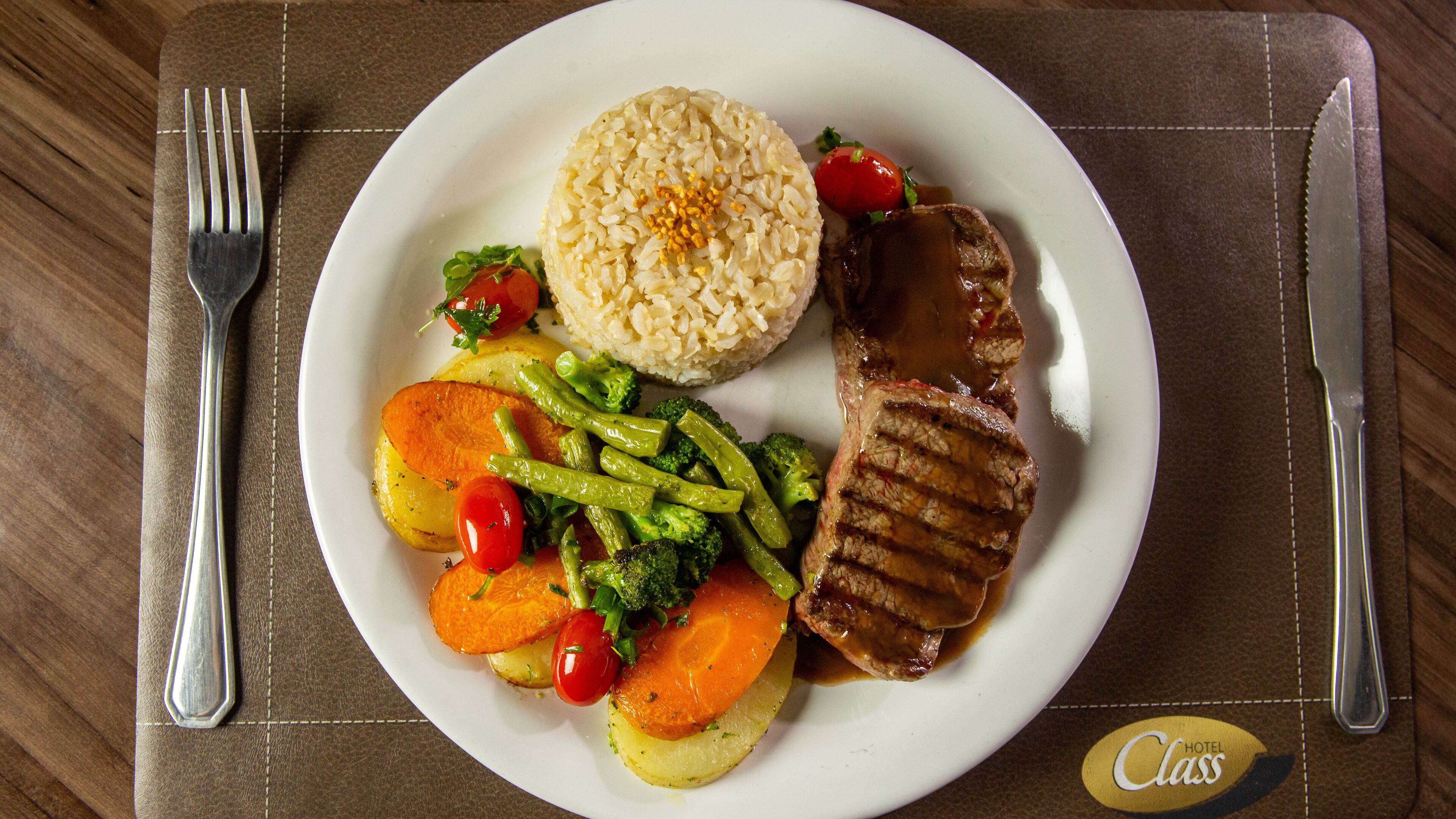 Un plato de comida con arroz, carne y verduras.