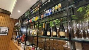A bar area with shelves of bottled beverages and glasses. - Class Hotel Piracicaba (Piracicaba)