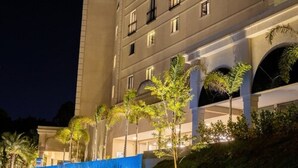 A multi-story hotel with a modern design, featuring a prominent entrance with a covered walkway and palm trees. - Class Hotel Piracicaba (Piracicaba)