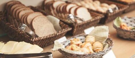 Ein Buffet mit verschiedenen Brotsorten und Gebäck, präsentiert in Körben.