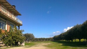 A building with a balcony, a grassy area, and rows of trees. - Self-catering single room for rent with a private bathroom (Marina di Montenero di Bisaccia)